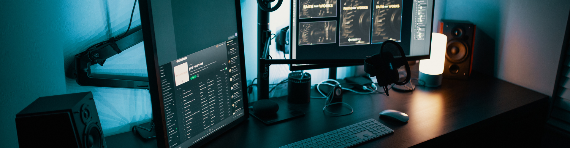 Cameras, computers, microphones and editing software screens arranged as a media production desk